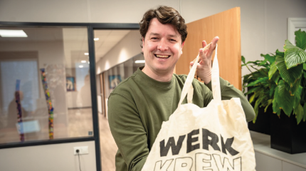 Harm geeft tas aan kandidaat die een nieuwe baan heeft gevonden via Werken in de Peel